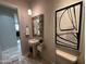 Elegant powder room featuring a pedestal sink, decorative mirror, and modern art at 37654 N 102Nd Pl, Scottsdale, AZ 85262