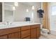 Bright bathroom with dual sinks, wood cabinets, and a shower behind a curtain at 37654 N 102Nd Pl, Scottsdale, AZ 85262