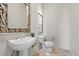 Elegant powder room featuring a decorative mirror and pedestal sink with stylish tile flooring and modern fixtures at 37654 N 102Nd Pl, Scottsdale, AZ 85262