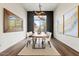 Contemporary dining room with modern light fixture and a large mirror reflecting the outdoor scenery at 37654 N 102Nd Pl, Scottsdale, AZ 85262