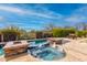 Inviting pool with spa and water feature surrounded by lush landscaping, offering a private and serene outdoor space at 37654 N 102Nd Pl, Scottsdale, AZ 85262