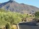 Gated community entrance with lush desert landscaping and scenic mountain views in background at 37654 N 102Nd Pl, Scottsdale, AZ 85262