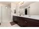 Bathroom featuring a double vanity with dark cabinets, white countertops, and a glass-enclosed shower area at 38062 W San Capistrano Ave, Maricopa, AZ 85138