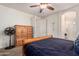 Cozy bedroom with a ceiling fan, a wooden dresser, and two doorways, one leading to a closet and the other to a bathroom at 38062 W San Capistrano Ave, Maricopa, AZ 85138