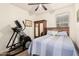 Cozy bedroom featuring a ceiling fan, an armoire, a wood headboard and exercise equipment at 38062 W San Capistrano Ave, Maricopa, AZ 85138