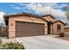 Single-story home featuring a two-car garage and low-maintenance desert landscaping at 38062 W San Capistrano Ave, Maricopa, AZ 85138