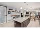 Spacious kitchen island with granite countertops, dark cabinets, and an open layout to the dining and living areas at 38062 W San Capistrano Ave, Maricopa, AZ 85138