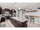 Well-equipped kitchen featuring an island with granite countertops, stainless steel appliances, and a sliding barn door at 38062 W San Capistrano Ave, Maricopa, AZ 85138