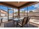 Relaxing screened-in patio with glass table and chairs perfect for enjoying the outdoors in comfort at 38062 W San Capistrano Ave, Maricopa, AZ 85138