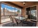 Inviting screened-in patio with glass table and chairs perfect for outdoor dining and relaxation at 38062 W San Capistrano Ave, Maricopa, AZ 85138