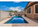 Sparkling swimming pool in a private backyard setting, bordered by a paved patio and mature landscaping at 38062 W San Capistrano Ave, Maricopa, AZ 85138