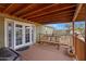 Relaxing covered porch with a cozy bench, double doors, and serene outdoor views at 38413 N 16Th St, Phoenix, AZ 85086