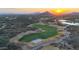 Scenic aerial shot of a well-manicured golf course set against a stunning desert landscape at sunset at 40262 N 107Th Pl, Scottsdale, AZ 85262