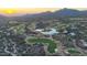 Expansive aerial view showcasing the rolling greens of a desert golf course surrounded by homes and mountains at 40262 N 107Th Pl, Scottsdale, AZ 85262