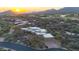 Aerial view of an upscale home nestled in a desert landscape with a golf course in the distance at sunset at 40262 N 107Th Pl, Scottsdale, AZ 85262