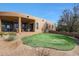 Spacious backyard featuring a putting green, desert landscape, and covered patio for outdoor enjoyment at 40262 N 107Th Pl, Scottsdale, AZ 85262