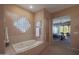 A bathtub with tile surround, a window block feature, and view to the primary bedroom at 40262 N 107Th Pl, Scottsdale, AZ 85262