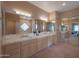 Spacious bathroom featuring double sinks, large mirrors, vanity, and view into primary bedroom at 40262 N 107Th Pl, Scottsdale, AZ 85262