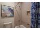 Cozy bathroom featuring a framed piece of art, warm tile shower with built-in niches, and decorative shower curtain at 40262 N 107Th Pl, Scottsdale, AZ 85262