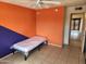 Bedroom featuring an orange and blue accent wall, ceiling fan and tiled floors at 4101 E Nancy Ln, Phoenix, AZ 85042