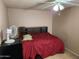 Bedroom with ceiling fan, tile floors and a red bedspread at 4101 E Nancy Ln, Phoenix, AZ 85042