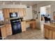 Functional kitchen with wooden cabinets, black appliances, and durable tiled countertops at 4101 E Nancy Ln, Phoenix, AZ 85042