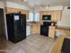 Functional kitchen with wooden cabinets, black appliances, and durable tiled countertops at 4101 E Nancy Ln, Phoenix, AZ 85042