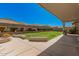 Landscaped backyard featuring a covered patio, lush lawn, and privacy fencing at 4109 E Del Rio St, Gilbert, AZ 85295