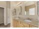 Bathroom featuring a double vanity with light wood cabinets, granite countertops, and decorative mirrors at 4109 E Del Rio St, Gilbert, AZ 85295