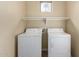 Functional laundry room featuring a washer, a dryer, and storage shelving at 4109 E Del Rio St, Gilbert, AZ 85295