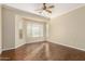 Bright living room with wood floors, ceiling fan, and plenty of natural light from the large window at 4109 E Del Rio St, Gilbert, AZ 85295