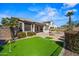 A stunning outdoor area featuring a lush putting green, in ground spa, a cozy fire pit, and tropical landscaping at 43851 W Griffis Dr, Maricopa, AZ 85138