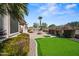 Beautiful backyard showcases a putting green, in ground spa, fire pit, covered patio, and lush landscaping at 43851 W Griffis Dr, Maricopa, AZ 85138