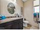 Elegant bathroom featuring granite counters, a decorative mirror, and a tiled shower with glass doors at 43851 W Griffis Dr, Maricopa, AZ 85138