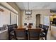 Well-lit dining area features a wooden table with leather chairs and stylish geometric light fixture at 43851 W Griffis Dr, Maricopa, AZ 85138