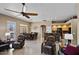 Open-concept living area with dining and kitchen featuring a ceiling fan and lots of light from the windows at 43851 W Griffis Dr, Maricopa, AZ 85138