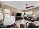 Spacious living room featuring comfortable seating, a ceiling fan, and large windows that fill the space with light at 43851 W Griffis Dr, Maricopa, AZ 85138