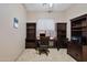 Home office featuring built-in dark wood desk, shelving, and neutral paint at 43851 W Griffis Dr, Maricopa, AZ 85138