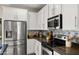 Close up of a stylish kitchen with stainless steel appliances, white cabinets, and patterned backsplash at 4521 W Kirkland Ave, San Tan Valley, AZ 85144