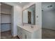 Bathroom vanity with double sinks, white cabinets and framed mirror, and closet access at 4655 S Glacier --, Mesa, AZ 85212