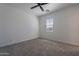 A bright bedroom featuring neutral carpeting, ceiling fan, and a window with natural light at 4655 S Glacier --, Mesa, AZ 85212