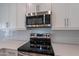 Stainless steel microwave and range, paired with white cabinets and countertops at 4655 S Glacier --, Mesa, AZ 85212