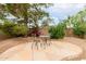 Cozy backyard patio area with stone pavers, seating, mature trees and bushes at 4662 W Fallen Leaf Ln, Glendale, AZ 85310