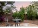 Inviting backyard patio with a metal table and chair set, lush landscaping, and a relaxing atmosphere at 4662 W Fallen Leaf Ln, Glendale, AZ 85310