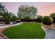 Beautiful backyard features a pool with rock waterfall and manicured lawn at 4662 W Fallen Leaf Ln, Glendale, AZ 85310