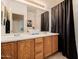 Bathroom featuring double sinks, oak cabinets, and a shower curtain at 4662 W Fallen Leaf Ln, Glendale, AZ 85310