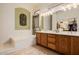 Bathroom with double sink vanity, a soaking tub, and decorative lighting at 4662 W Fallen Leaf Ln, Glendale, AZ 85310