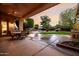 Enjoy the outdoors from this covered patio overlooking the pool and lush landscaping at dusk at 4662 W Fallen Leaf Ln, Glendale, AZ 85310