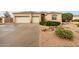 Home featuring a three-car garage, neutral color scheme, desert landscaping, and well manicured shrubbery at 4662 W Fallen Leaf Ln, Glendale, AZ 85310