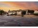 Beautiful single-story home featuring a three-car garage, desert landscaping, and a tile roof against a colorful sky at 4662 W Fallen Leaf Ln, Glendale, AZ 85310